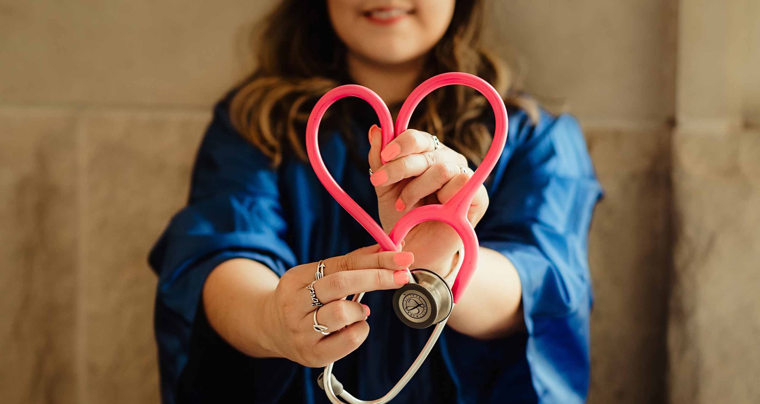 Mladá žena tvoří srdce se stetoskopem